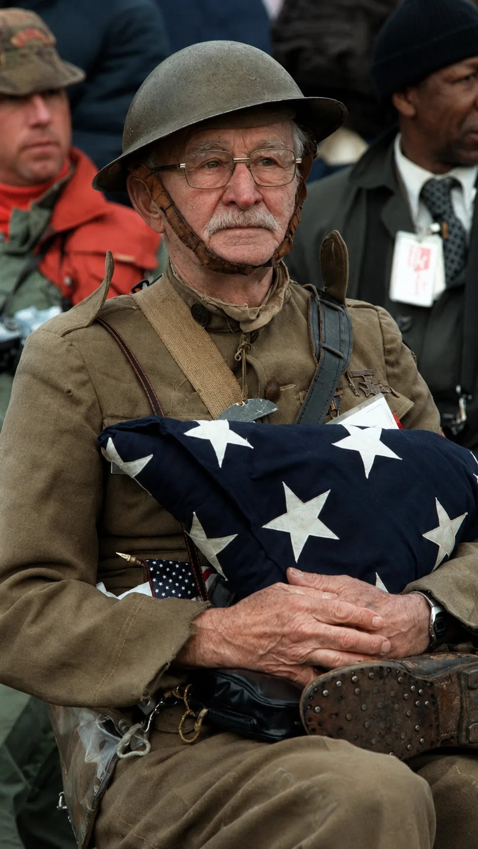 Explore the life story of a distinguished veteran, captured in a poignant photograph with an American flag. A tale of de